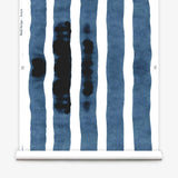 Wallpaper roll with bold watercolor stripes in inky blue and white on a white background.