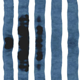 Wallpaper close up with bold watercolor stripes in inky blue and white. 