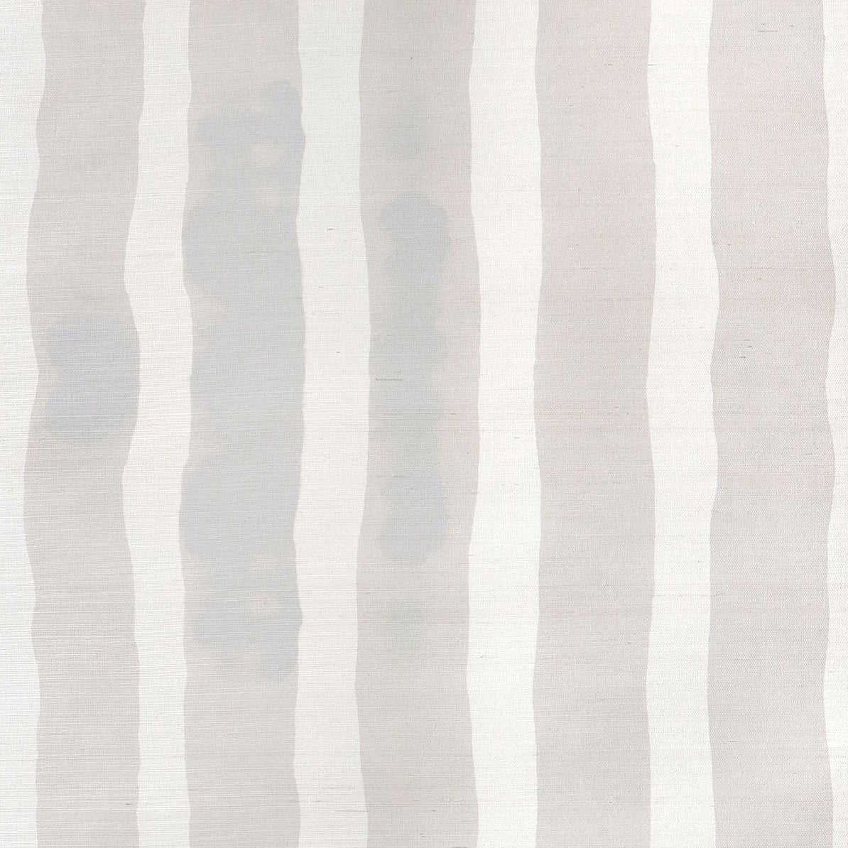Grasscloth Wallpaper close up with bold watercolor stripes in greige and white. 
