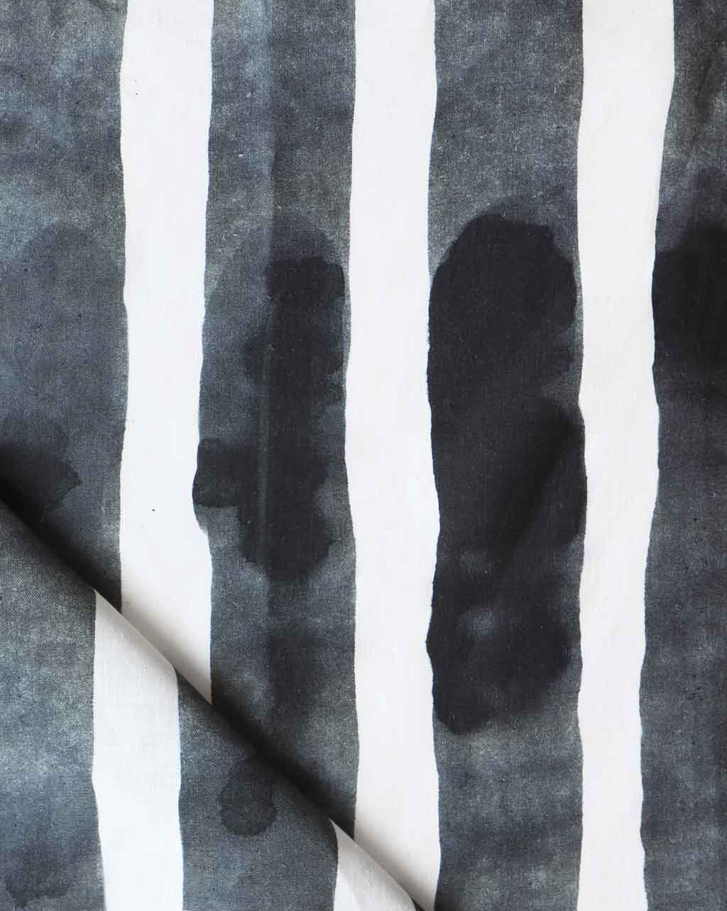 Folded printed linen with bold watercolor stripes in black and white. 