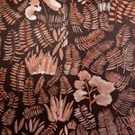 Detail of wallpaper in a playful leaf print in shades of orange and coral on a brown field.