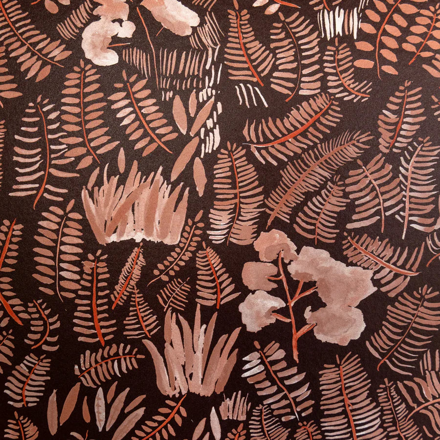 Detail of wallpaper in a playful leaf print in shades of orange and coral on a brown field.