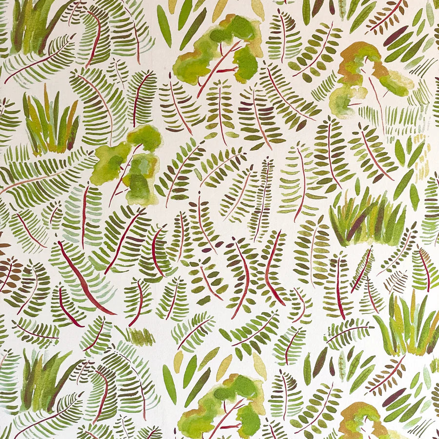 Detail of wallpaper in a playful leaf print in shades of green and red on a cream field.