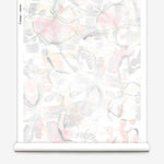 Partially unrolled wallpaper yardage in a watercolor painterly print in shades of pastel, green and cream.