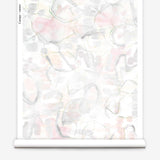 Partially unrolled wallpaper yardage in a watercolor painterly print in shades of pastel, green and cream.