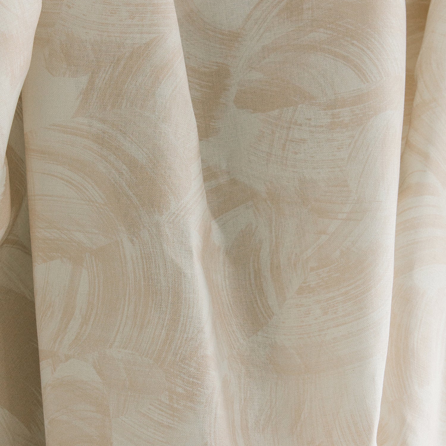 Draped fabric yardage in an absract paint swatch print in light pink on a cream field.