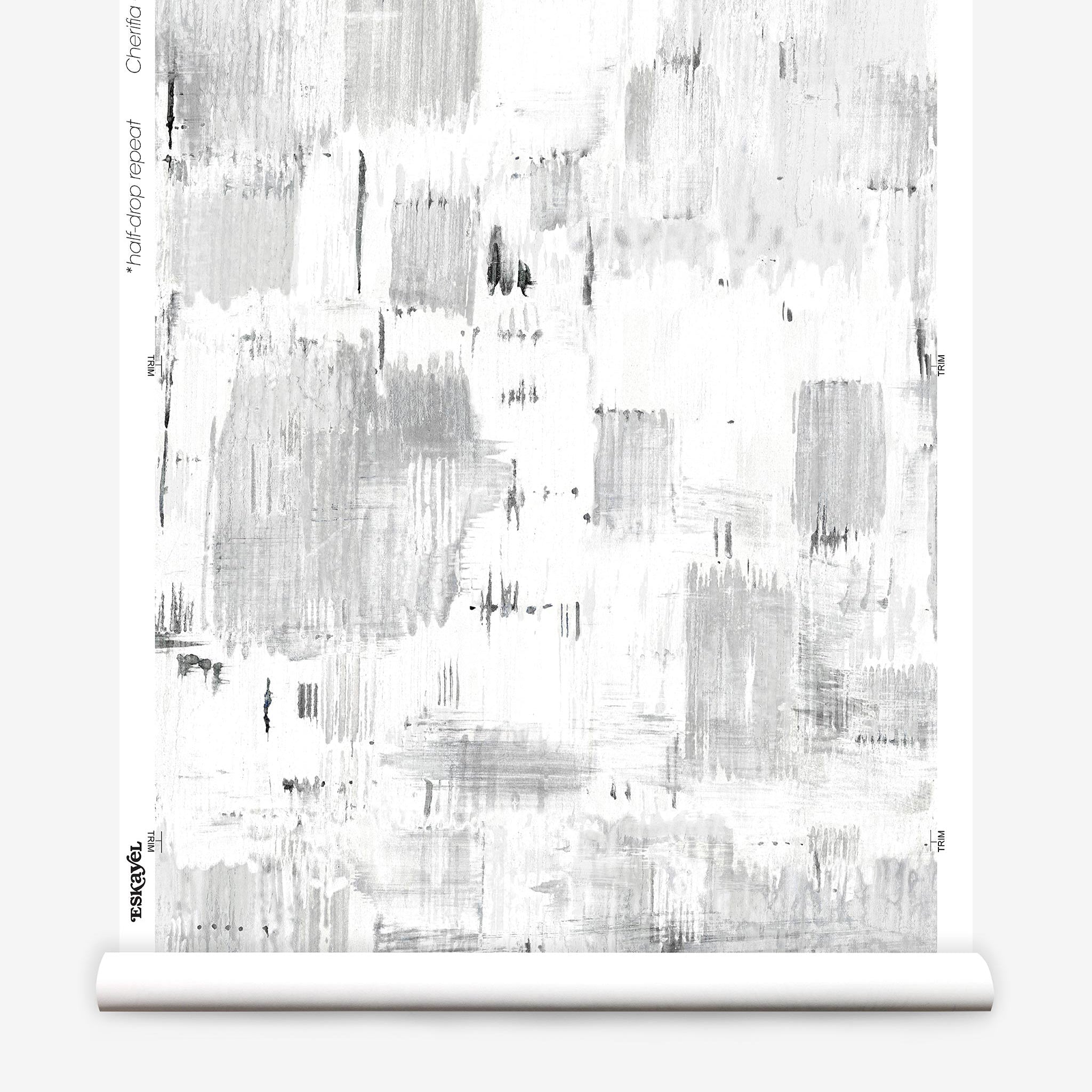 Partially unrolled wallpaper yardage in a watercolor textural print in shades of gray on a white field.