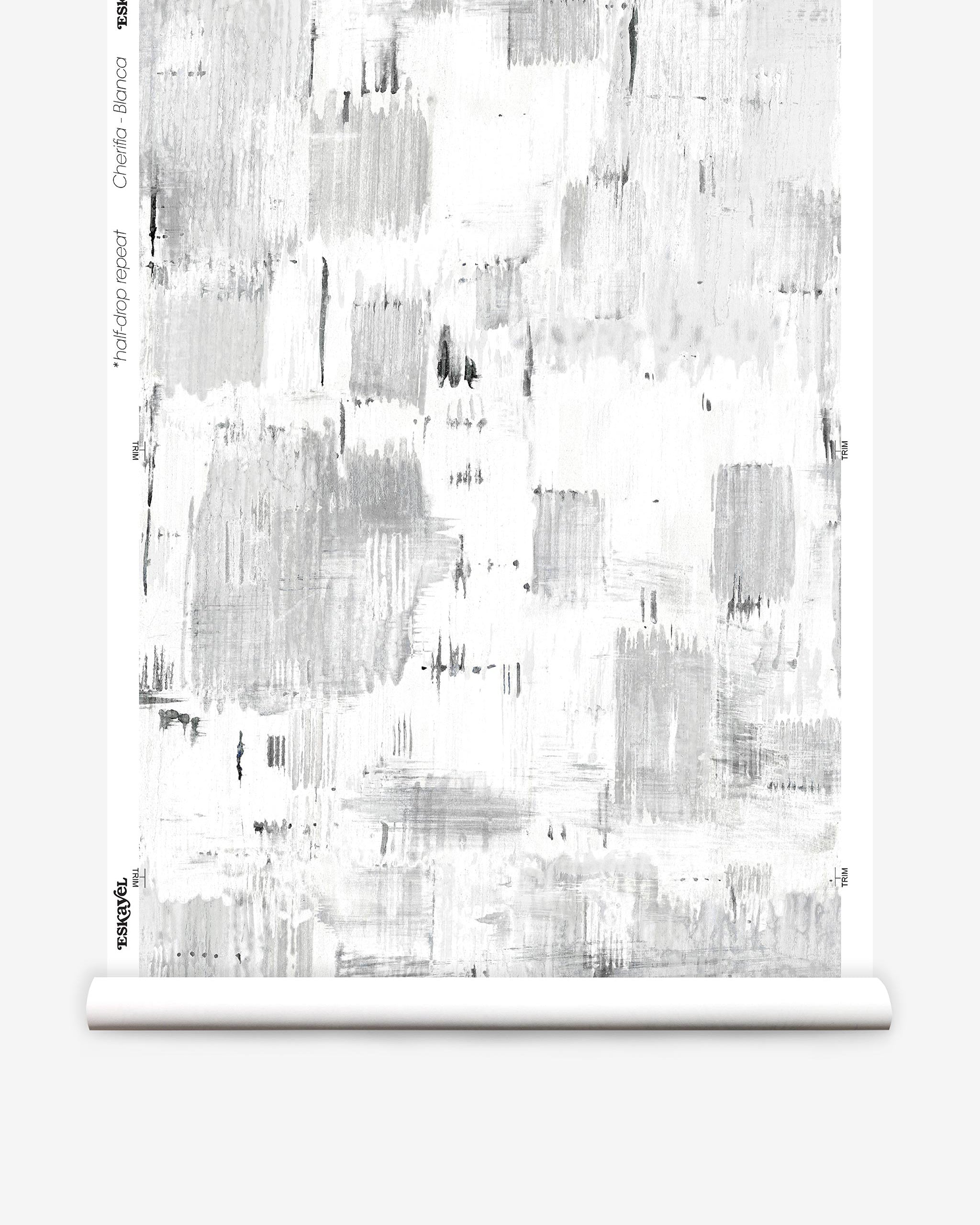 Partially unrolled wallpaper yardage in a watercolor textural print in shades of gray on a white field.