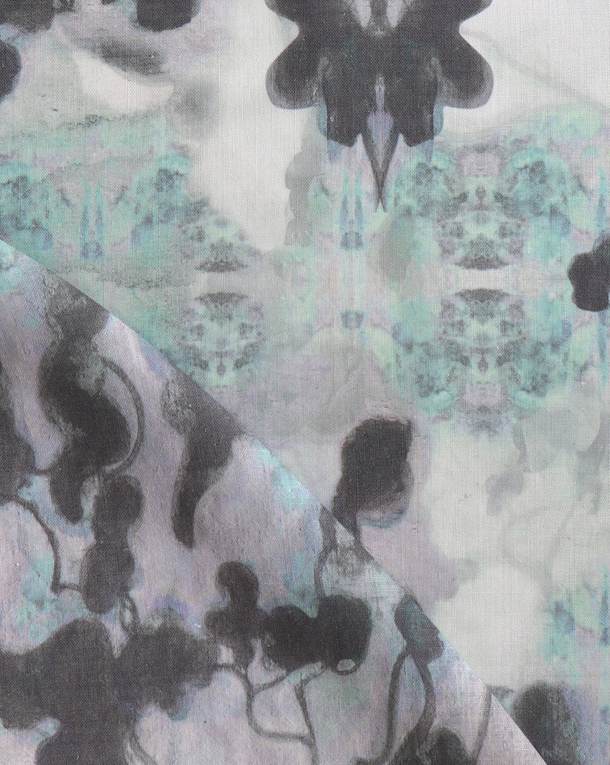 Detail of fabric in a watercolor tree print in shades of purple, turquoise and gray on a white field.