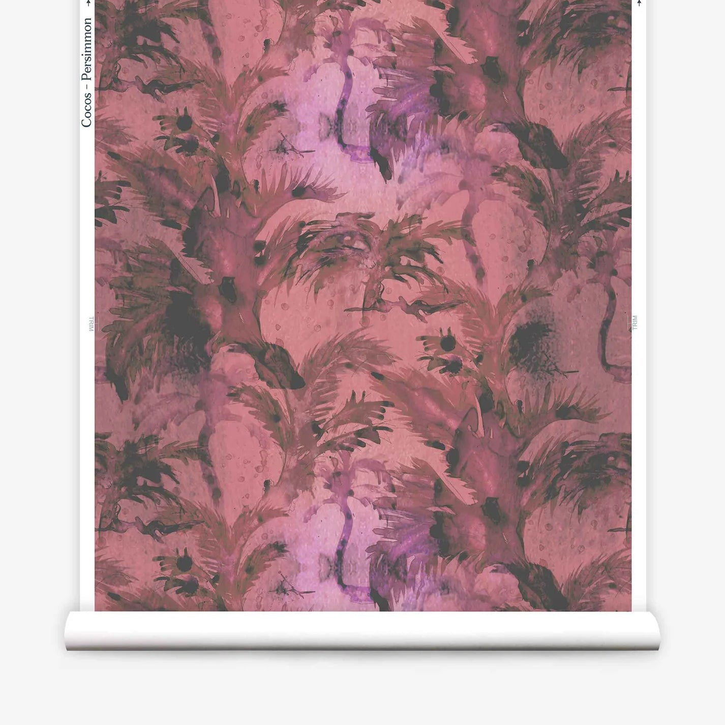 Partially unrolled wallpaper yardage in a painterly palm tree print in shades of red, pink and gray.