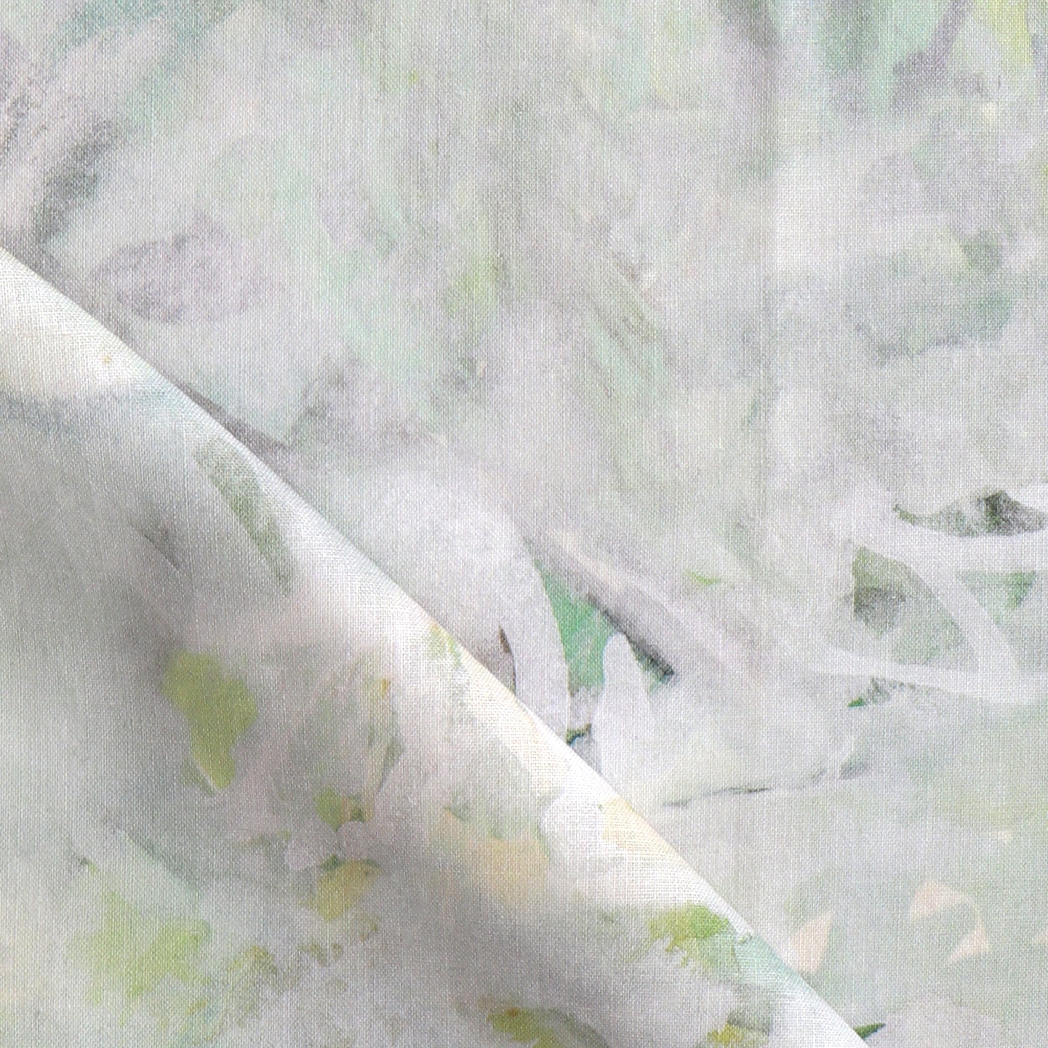 Detail of fabric in a watercolor painterly print in light gray, green and brown on a cream field.
