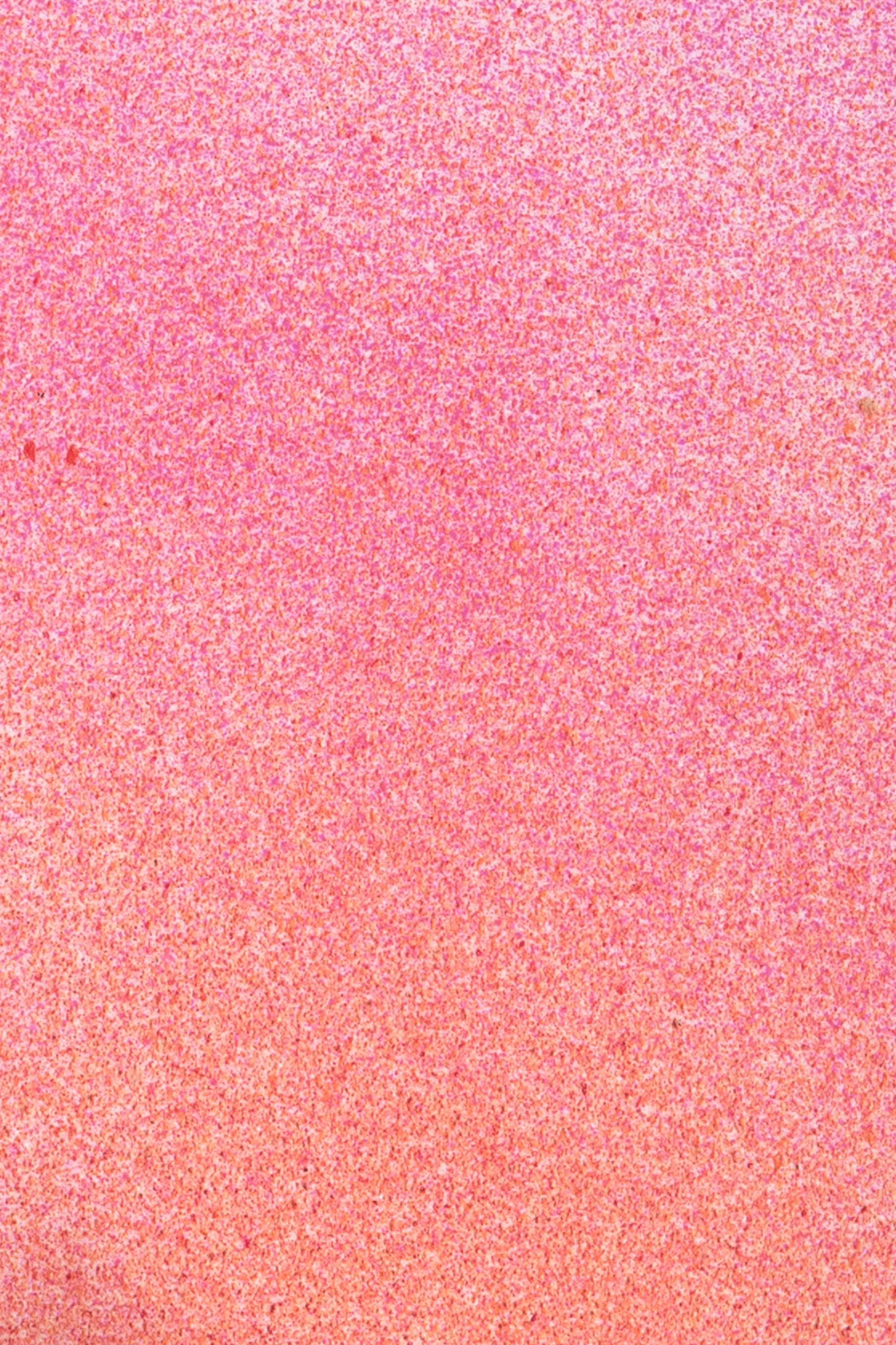 Close up of paint splatters in pink and orange.
