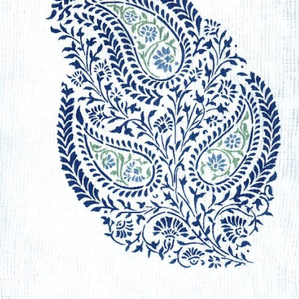 Detail of fabric in a botanical paisley in navy and green on a white field.