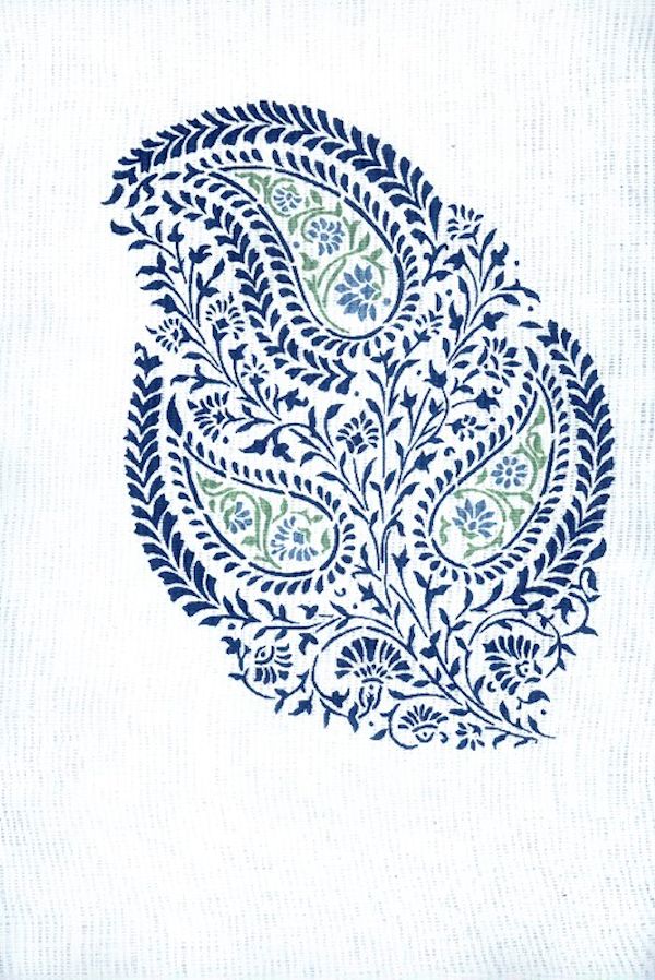 Detail of fabric in a botanical paisley in navy and green on a white field.