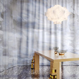 Modern interior with a light fixture, table, and abstract patterned curtain
