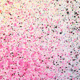 Close up of paint splatters in pink, black and yellow.