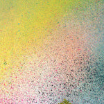 A vase of flowers stands in front of a wall covered in an abstract ombré paint splatter print in pink, yellow, blue and green.