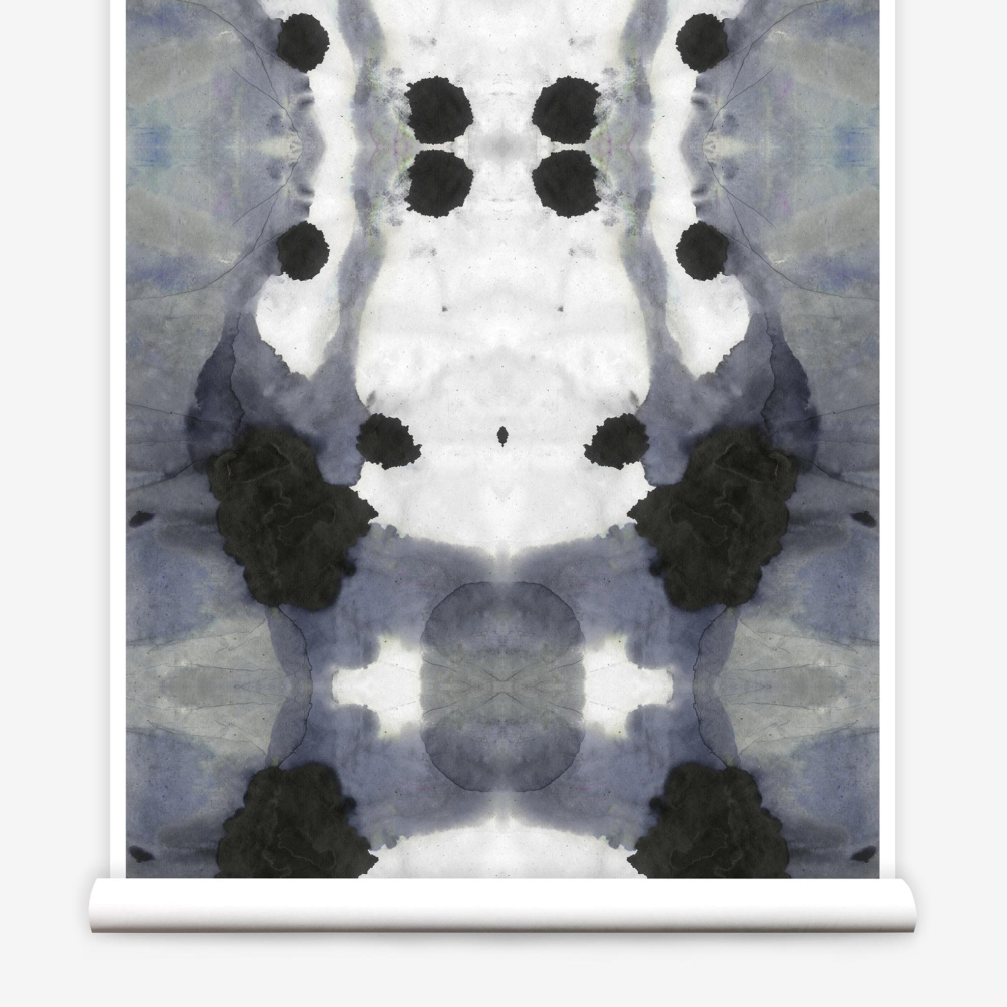 Partially unrolled wallpaper yardage in a watercolor ink blot print in charcoal, gray and white.