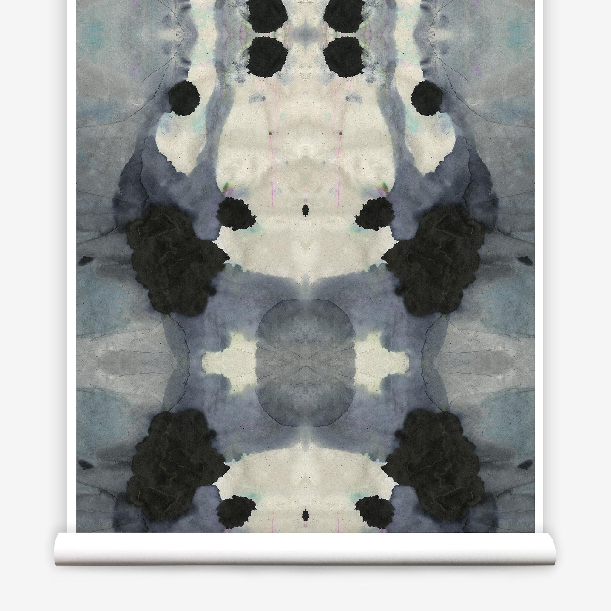 Partially unrolled wallpaper yardage in a watercolor ink blot print in charcoal, gray and tan.