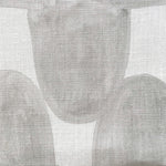 Close-up of fabric in an abstract scalloped print in gray on a white field.