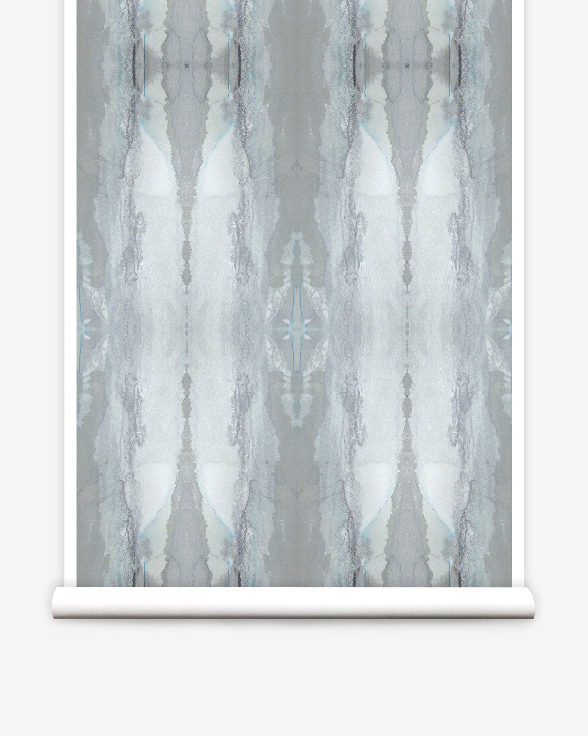 Partially unrolled wallpaper yardage in a watercolor textural print in shades of gray and blue-gray.