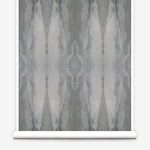 Partially unrolled wallpaper yardage in a watercolor textural print in shades of gray.