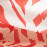 Draped fabric yardage in a playful broken stripe print in coral on a cream field.