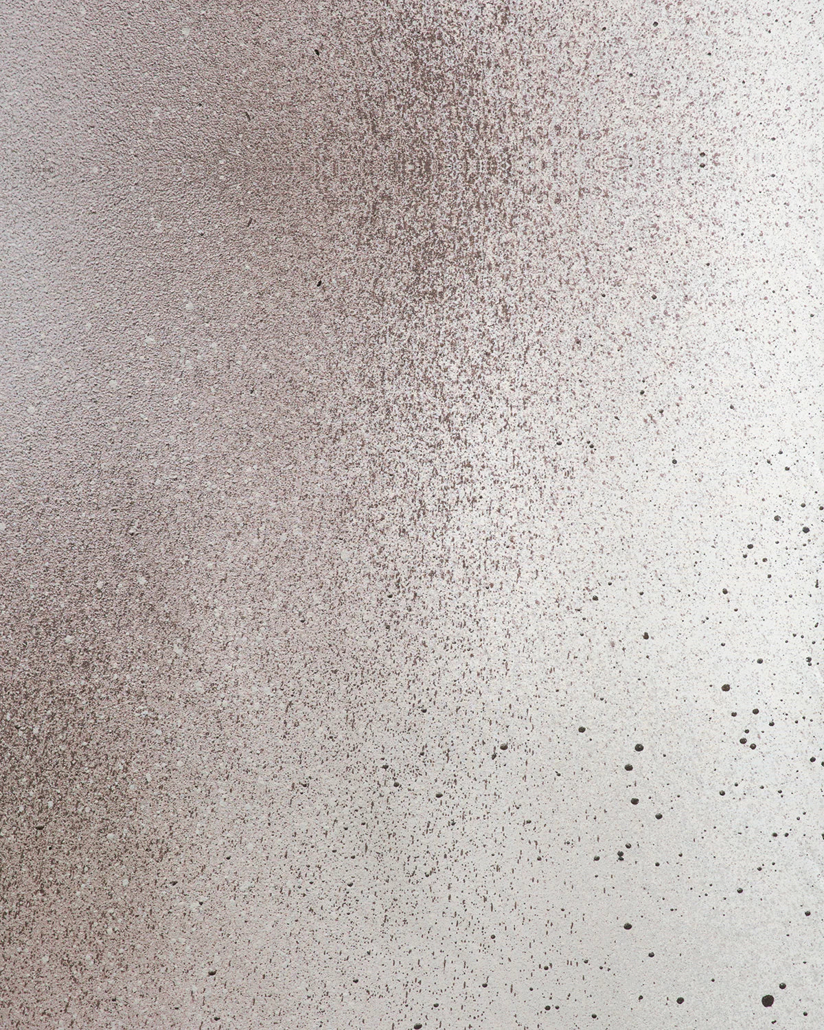 Detail of fabric in an abstract ombré paint splatter print in shades of gray and white.