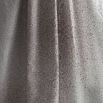 Draped fabric yardage in an abstract ombré paint splatter print in shades of gray and white.
