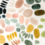 Detail of wallpaper in a playful paint blotch print in shades of green, pink and yellow on a white field.