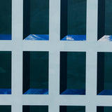 Detail of wallpaper in a dimensional grid print in shades of blue, navy and turquoise.