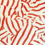 Detail of wallpaper in a playful broken stripe print in red on a cream field.