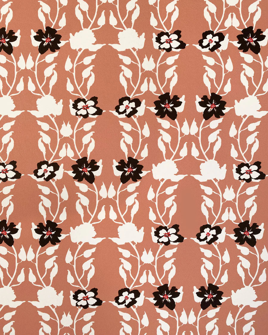 Detail of wallpaper in a linear floral print in red, white and black on an orange field.