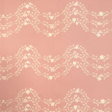 Detail of wallpaper in a curving floral stripe print in shades of cream on a pink field.