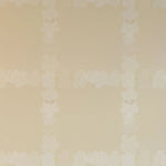 Detail of wallpaper in a floral grid print in cream on a tan field.