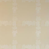 Detail of wallpaper in a floral grid print in cream on a tan field.