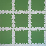 Detail of wallpaper in a floral grid print in white on a green field.