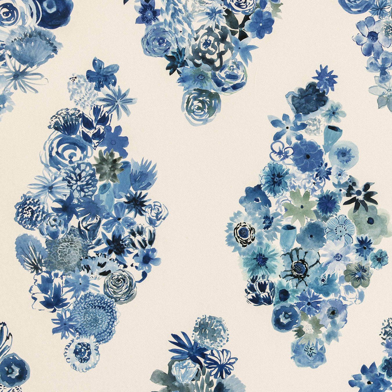 Detail of fabric in a painterly floral print in shades of blue and navy on a cream field.