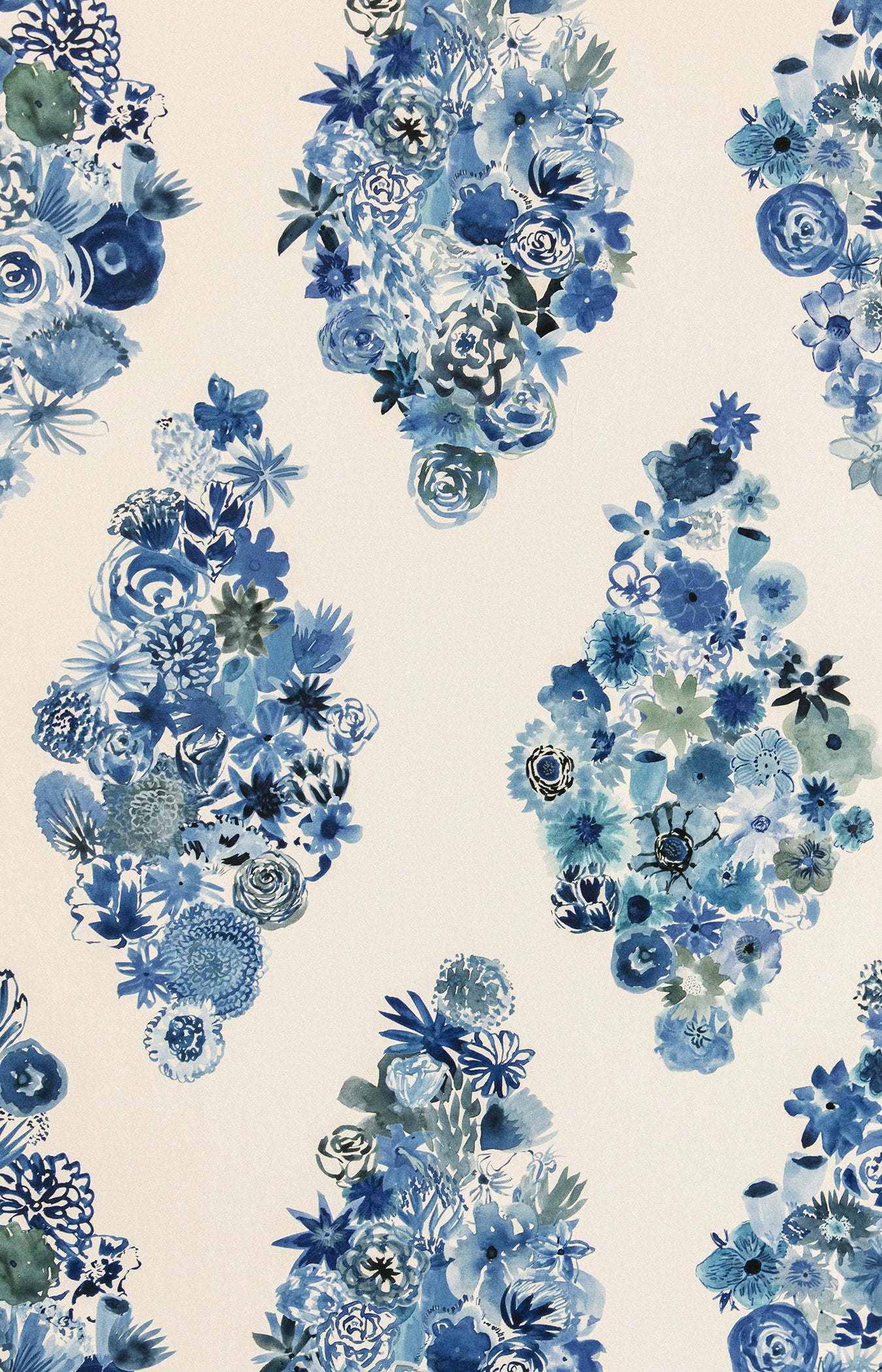 Detail of fabric in a painterly floral print in shades of blue and navy on a cream field.
