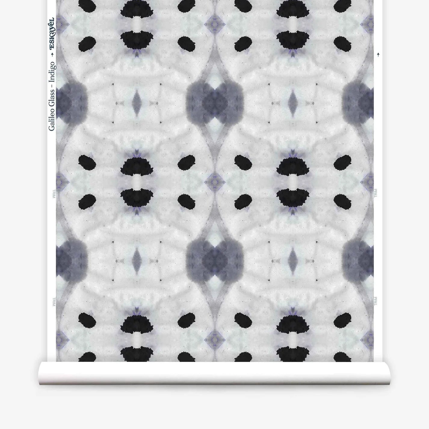 Partially unrolled wallpaper yardage in a watercolor ink blot print in shades of charcoal and black on a greige field.