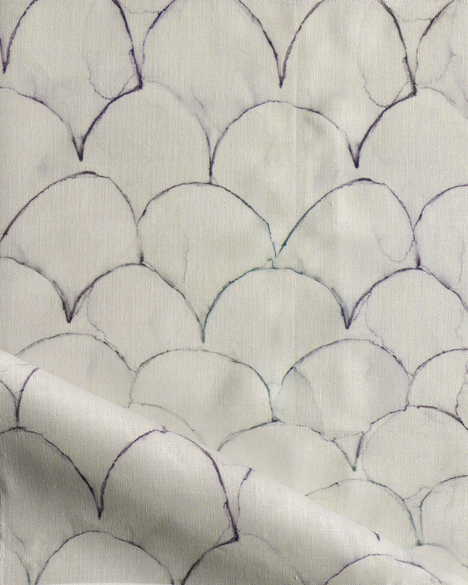 Detail of draped fabric in a watercolor linear scallop pattern in navy on a cream field. 