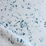 Detail of draped fabric in a painterly bandana print in navy on a white field.