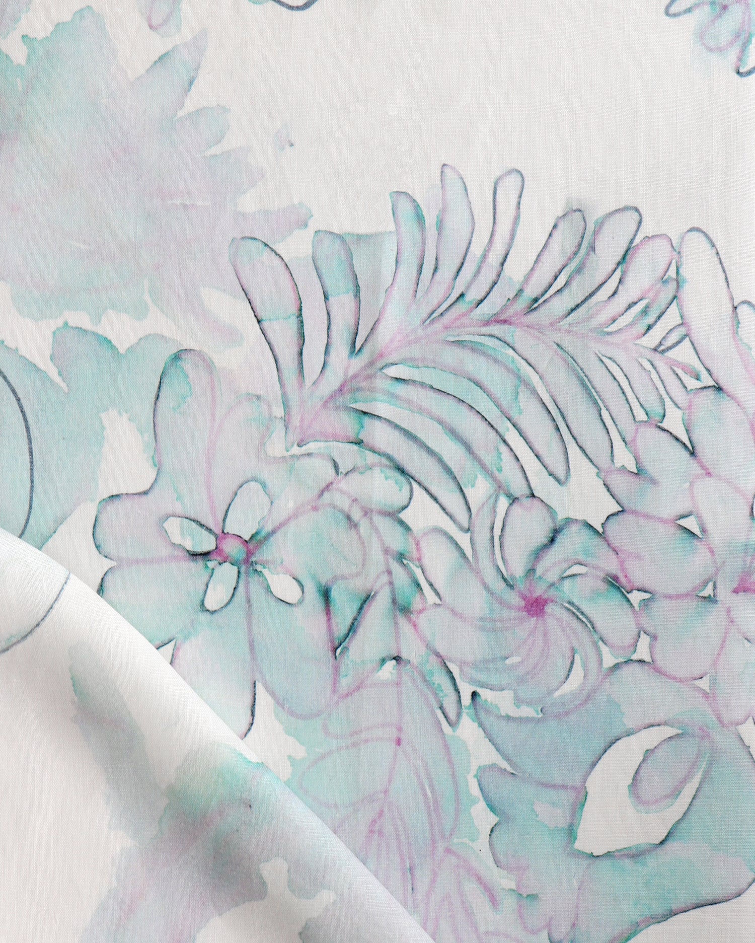 Detail of draped fabric in a painterly floral print in shades of green and purple on a white field.