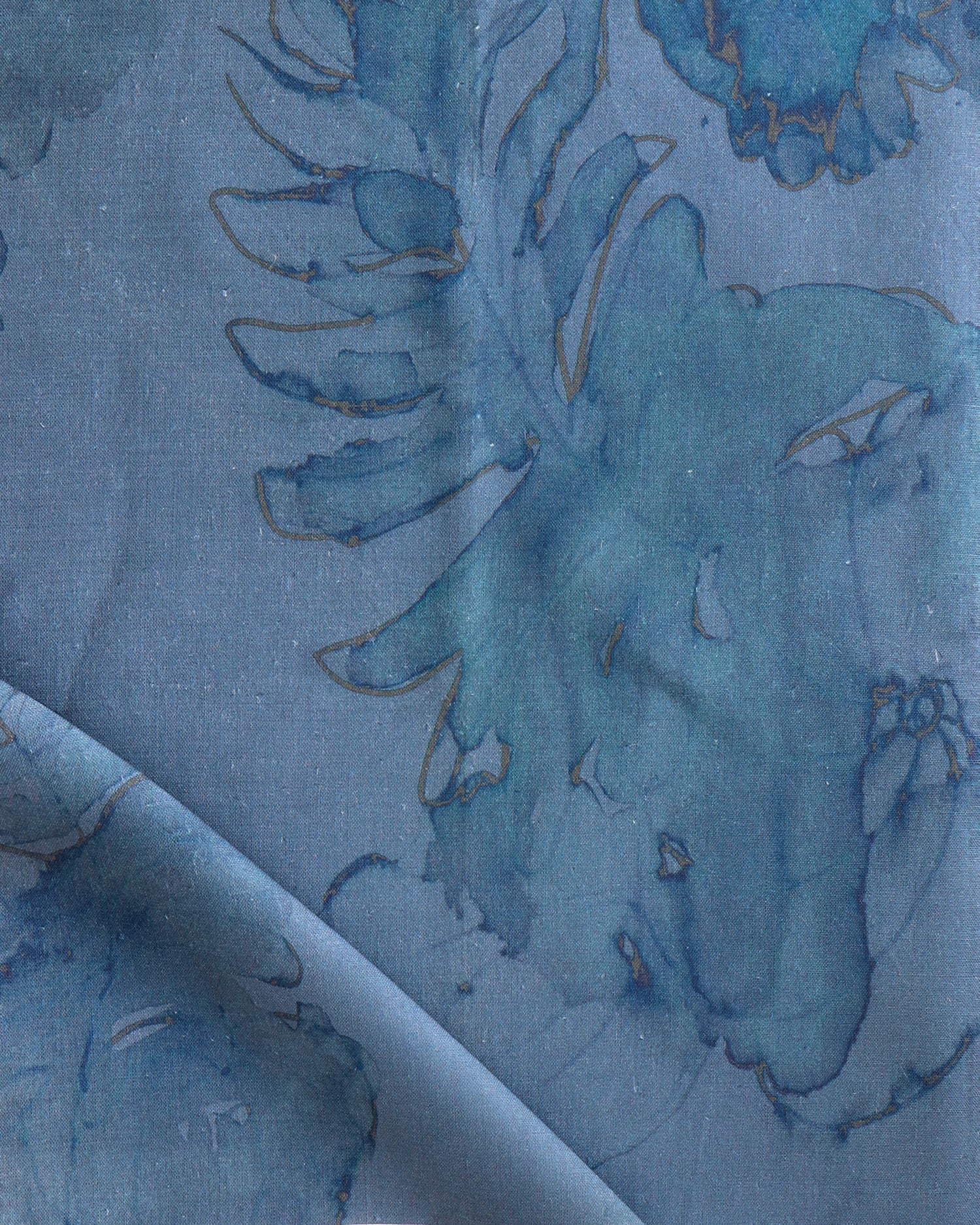 Detail of draped fabric in a painterly floral print in shades of navy and tan on a blue field.
