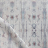 Detail of draped fabric in a painterly ikat print in turquoise, gray and tan.