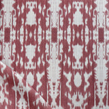 Detail of draped fabric in a painterly ikat print in rust and white.