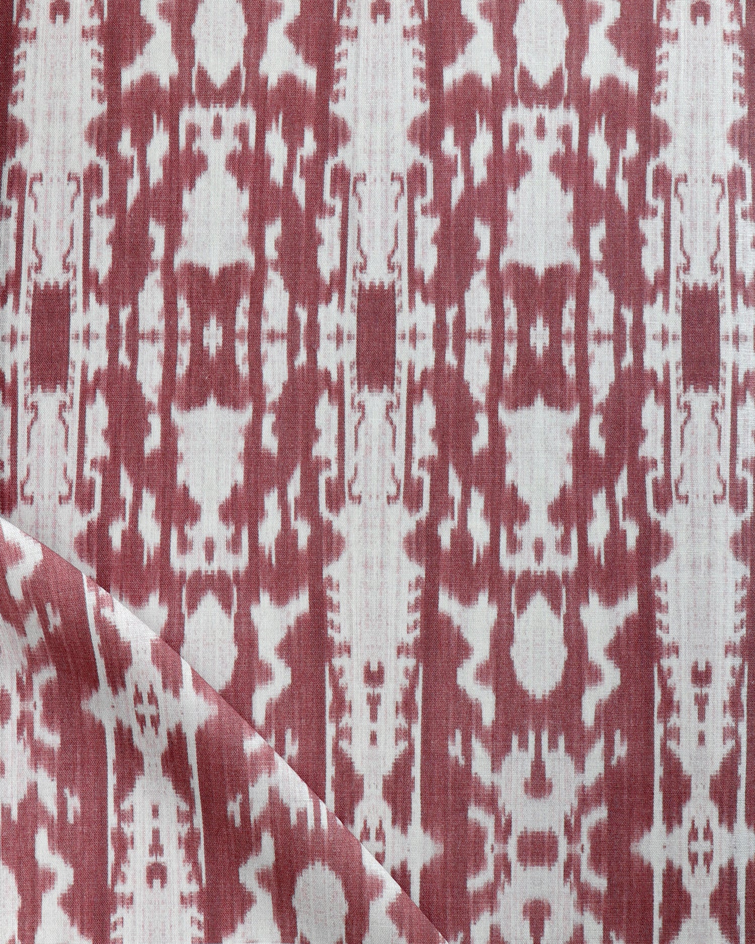 Detail of draped fabric in a painterly ikat print in rust and white.