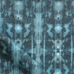 Detail of draped fabric in a painterly ikat print in turquoise and navy.