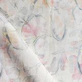Detail of draped fabric in a watercolor painterly print in shades of pastel, green and cream.