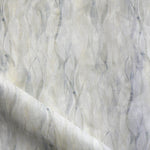 Draped fabric in a layered squiggle watercolor pattern in shades of grey and warn tan, 